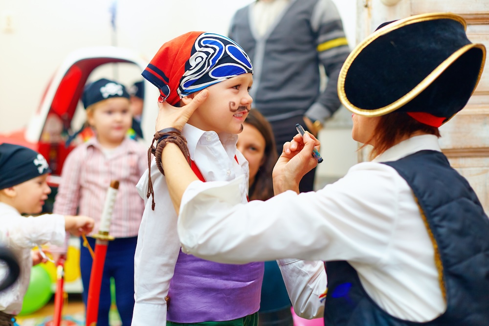 woman painting kid's face on party