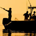silhouette of sport fishing boat reflecting on calm water