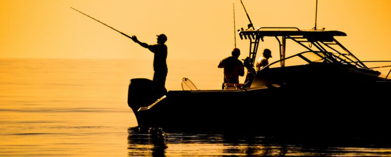 silhouette of sport fishing boat reflecting on calm water