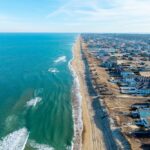 Kill Devil Hills, North Carolina, aerial view of the Atlantic coastline featuring sandy beaches, vacation homes, and the expansive Outer Banks landscape.