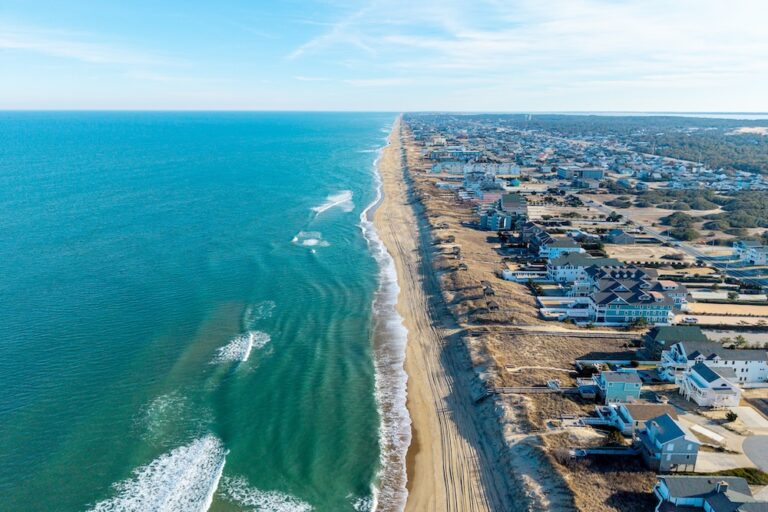 Kill Devil Hills, North Carolina, aerial view of the Atlantic coastline featuring sandy beaches, vacation homes, and the expansive Outer Banks landscape.